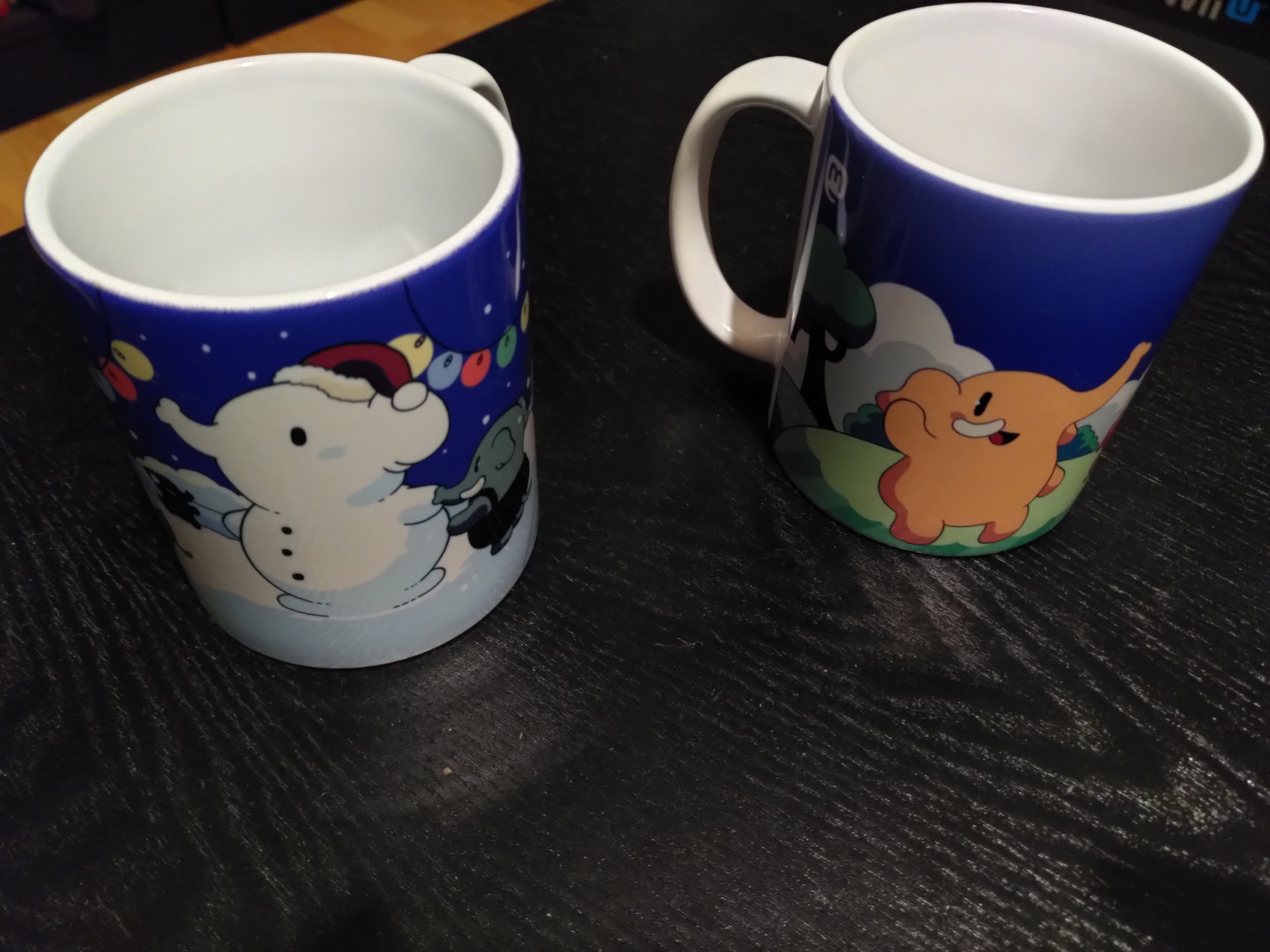 Les deux mugs Mastodon officiels, le classique avec des éléphants rigolos, et la version hiver avec des éléphants rigolos dont un en neige avec un bonnet de Père Noël.